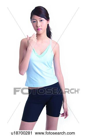 Stock Image - Young woman standing and holding something. Fotosearch