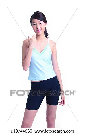 Stock Image - Young woman standing and holding something. Fotosearch