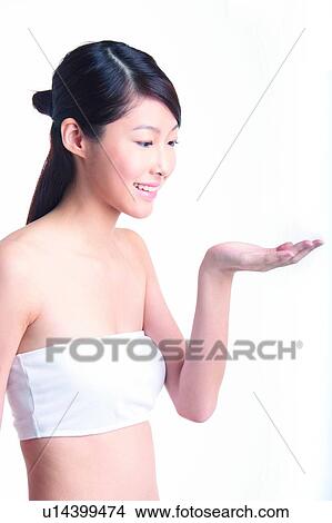 Picture - Young woman standing and looking at palm. Fotosearch