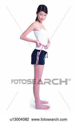 Young woman standing and measuring, full length, side view View Large Photo Image Stock Image - Young woman standing and measuring, full length, side view. Fotosearch