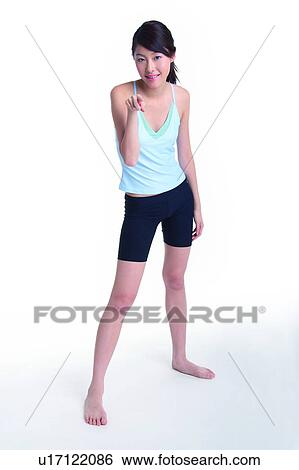 Stock Photograph - Young woman standing and pointing at you. Fotosearch