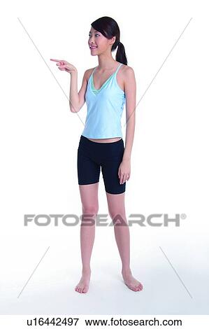 Young woman standing and pointing to left View Large Photo Image Stock Photo - Young woman standing and pointing to left. Fotosearch