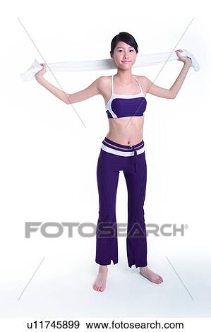 Stock Photo - Young woman standing and pulling towel. Fotosearch