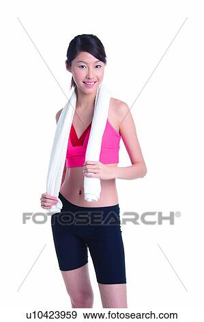 Stock Photo - Young woman standing with towel on neck. Fotosearch