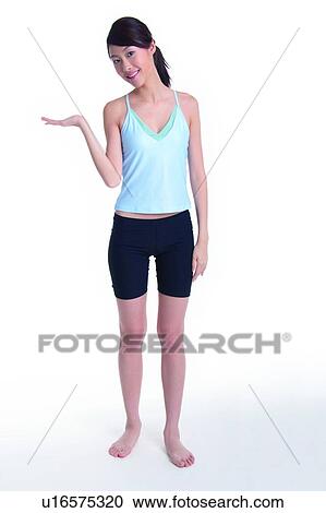 Stock Image - Young woman standing with welcoming pose. Fotosearch