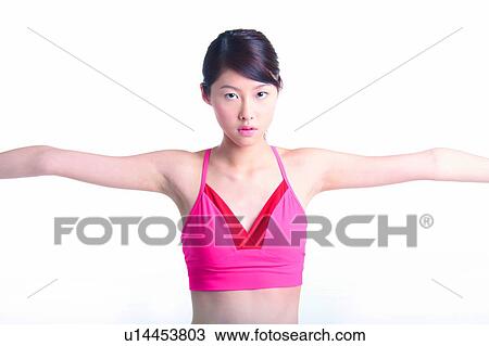 Stock Image - Young woman stretching and looking at camera. Fotosearch