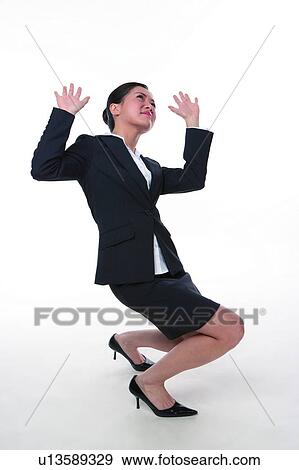 Stock Photo - Young woman in business suit, hand up, supporting heavy things. Fotosearch