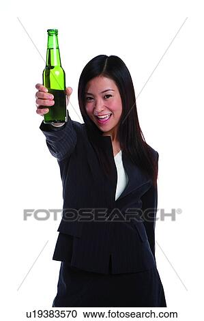 Young woman in business suit, holding bottle of beer in front View Large Photo Image Stock Image - Young woman in business suit, holding bottle of beer in front. Fotosearch