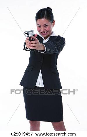 Young woman in business suit, holding gun, shooting, front view View Large Photo Image Stock Photo - Young woman in business suit, holding gun, shooting, front view. Fotosearch