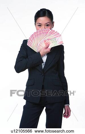 Stock Photograph - Young woman in business suit, holding money in front. Fotosearch