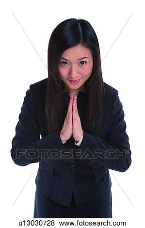 Stock Photo - Young woman in business suit, palms together. Fotosearch