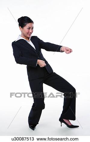 Stock Image - Young woman in business suit, pulling something. Fotosearch