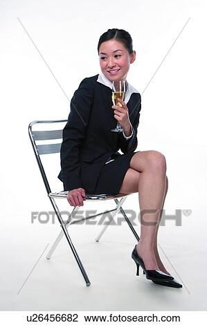 Young woman in business suit, sitting, holding a glass of wine, full length View Large Photo Image Stock Image - Young woman in business suit, sitting, holding a glass of wine, full length. Fotosearch