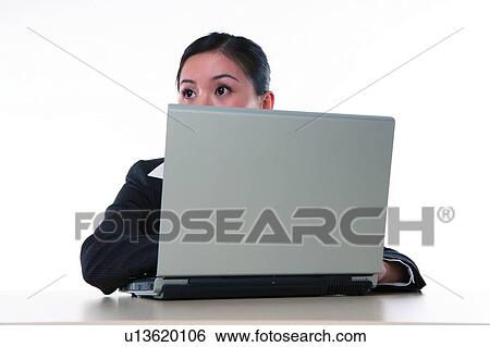 Stock Photograph - Young woman in business suit, sitting, looking away. Fotosearch