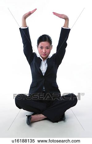 Stock Photography - Young woman in business suit, sitting with legs crossed. Fotosearch