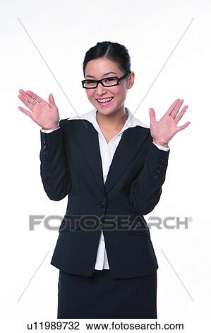Stock Image - Young woman in business suit, standing with palms open. Fotosearch