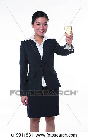 Young woman in business suit, standing, raising a glass of wine View Large Photo Image Stock Image - Young woman in business suit, standing, raising a glass of wine. Fotosearch
