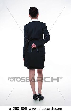 Young woman in business suit, standing, hand on back, rear view View Large Photo Image Stock Photograph - Young woman in business suit, standing, hand on back, rear view. Fotosearch