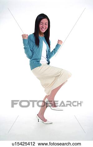 Stock Image - Young woman standing on one leg, in big happiness. Fotosearch