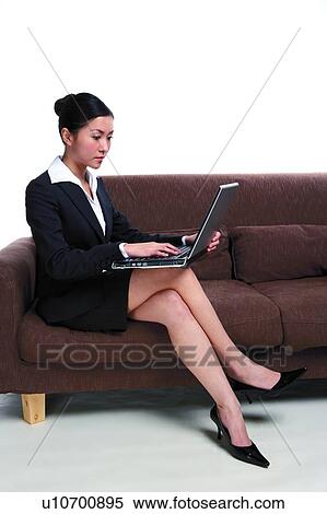 若い女性 中に スーツ ソファーの上に座る ラップトップを使用して ストックフォト 写真素材 U Fotosearch