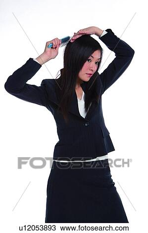 Stock Image - Young woman in business suit, combing. Fotosearch