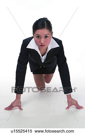 Stock Photography - Young woman in business suit, hands on ground supporting body. Fotosearch
