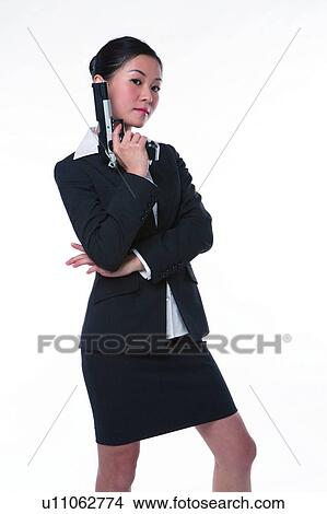 Young woman in business suit, holding gun, side view View Large Photo Image Picture - Young woman in business suit, holding gun, side view. Fotosearch
