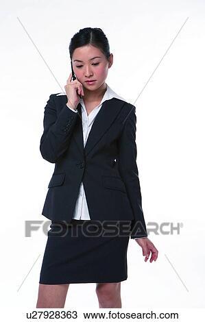 Young woman in business suit, holding mobile phone View Large Photo Image Stock Image - Young woman in business suit, holding mobile phone. Fotosearch
