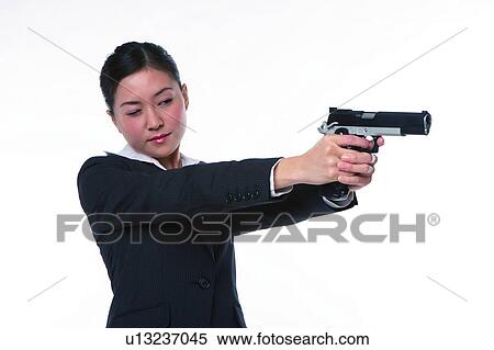 Young woman in business suit, holding gun, shooting, close-up View Large Photo Image Stock Photography - Young woman in business suit, holding gun, shooting, close-up. Fotosearch