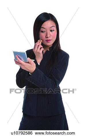 Young woman in business suit, making-up View Large Photo Image Stock Photograph - Young woman in business suit, making-up. Fotosearch