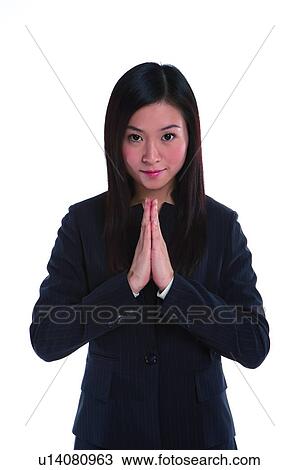 Stock Image - Young woman in business suit, palms together. Fotosearch