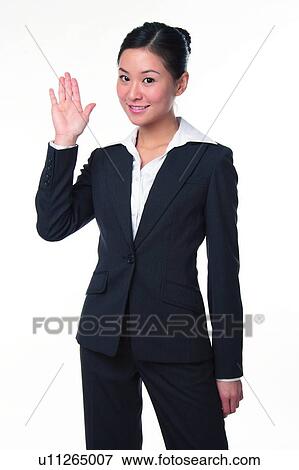 Young woman in business suit, raising hand View Large Photo Image Stock Photo - Young woman in business suit, raising hand. Fotosearch