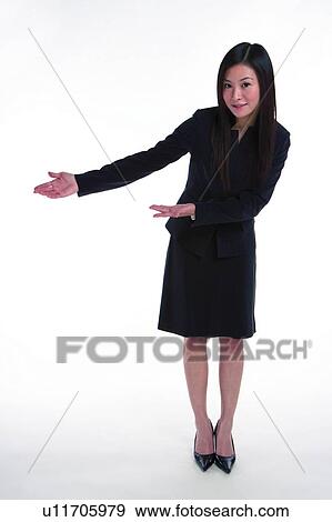 Stock Photo - Young woman in business suit, showing way to left. Fotosearch