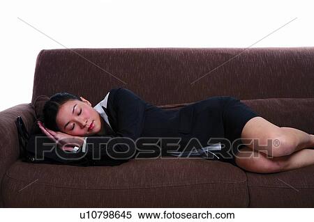 Stock Photography - Young woman in business suit, sleeping on sofa. Fotosearch