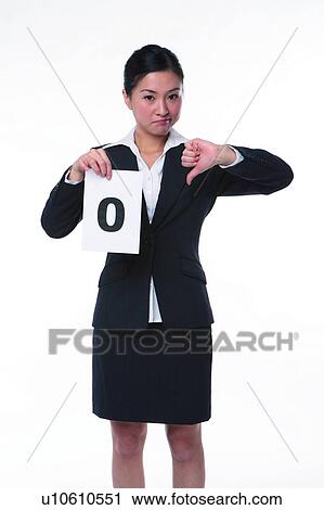 Stock Image - Young woman in business suit, standing, holding a paper marked with "0". Fotosearch