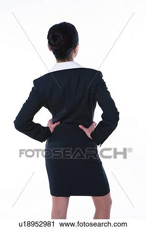 Young woman in business suit, standing with hands on waist, rear view View Large Photo Image Stock Image - Young woman in business suit, standing with hands on waist, rear view. Fotosearch