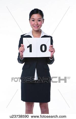 Young woman in business suit, standing, holding a sign of "10" View Large Photo Image Stock Image - Young woman in business suit, standing, holding a sign of "10". Fotosearch