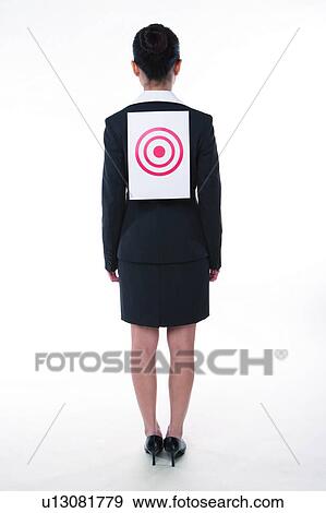 Young woman in business suit, standing, wearing a target on back, rear view, full length View Large Photo Image Stock Photo - Young woman in business suit, standing, wearing a target on back, rear view, full length. Fotosearch