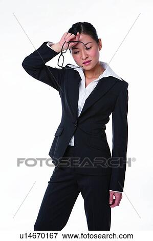 Stock Photo - Young woman in business suit, standing and holding spectacles. Fotosearch