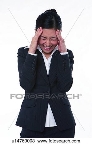 Stock Photo - Young woman in business suit, standing, hands on head, screaming. Fotosearch