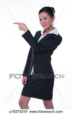 Young woman in business suit, standing, pointing to the left View Large Photo Image Stock Photo - Young woman in business suit, standing, pointing to the left. Fotosearch