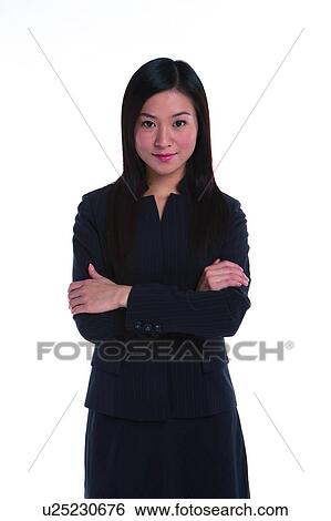 Stock Photograph - Young woman in business suit, standing in confidence, front view. Fotosearch