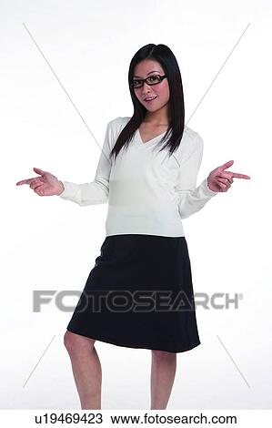 Stock Image - Young woman in business suit, wearing glasses, pointing to right and left. Fotosearch