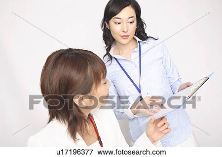 Stock Photo - Bbusiness lady holding a short meeting. Fotosearch