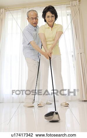 Stock Image - Elderly couple who practices golf. Fotosearch