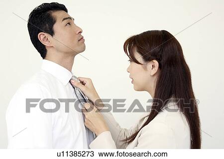 Stock Image - Husband who has a wife put on a tie. Fotosearch