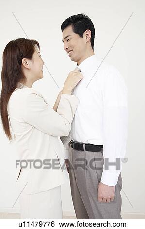 Husband who has a wife put on a tie View Large Photo Image Stock Photograph - Husband who has a wife put on a tie. Fotosearch