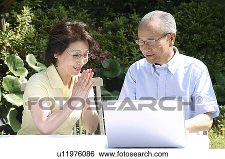 Stock Photograph - Old douple operating a PC. Fotosearch