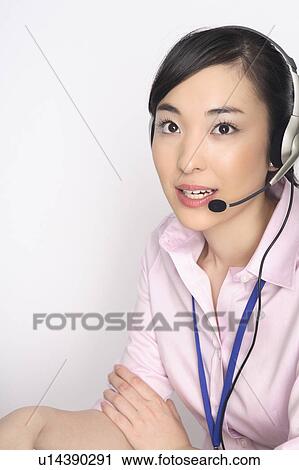 Stock Image - Business lady talking in headset. Fotosearch
