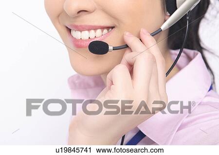 Stock Image - Business lady talking in headset. Fotosearch